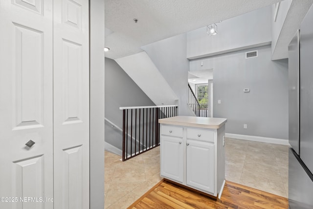 4000 Grande Vista Blvd Unit 15-106, Saint Augustine, FL 32084 - kitchen with white cabinetry, a textured ceiling, light tile patterned floors, light countertops, and refrigerator