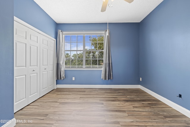 4000 Grande Vista Blvd Unit 15-106, Saint Augustine, FL 32084 - unfurnished bedroom featuring a closet, wood finished floors, a textured ceiling, and a ceiling fan
