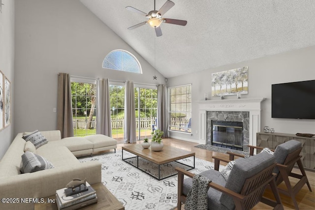 1430 Spindrift Cir E, Neptune Beach, FL 32266 - living area with a ceiling fan, high vaulted ceiling, a textured ceiling, a fireplace, and wood finished floors