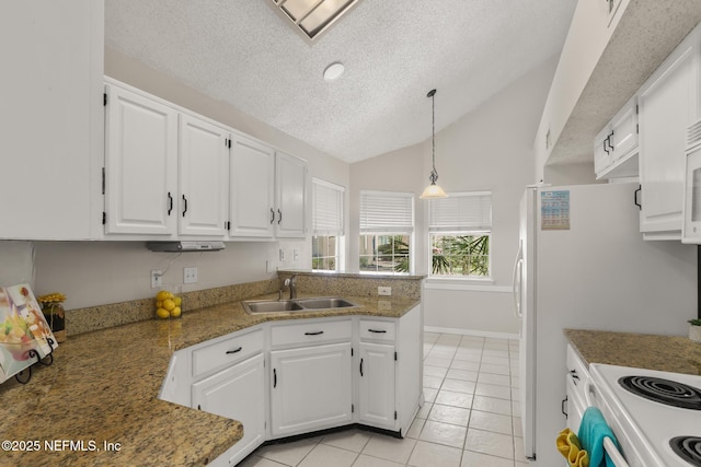 1430 Spindrift Cir E, Neptune Beach, FL 32266 - kitchen featuring a textured ceiling, white cabinetry, light tile patterned floors, a peninsula, and vaulted ceiling