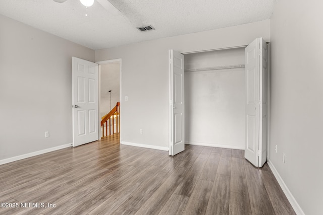 1430 Spindrift Cir E, Neptune Beach, FL 32266 - unfurnished bedroom featuring wood finished floors, a textured ceiling, a closet, and ceiling fan