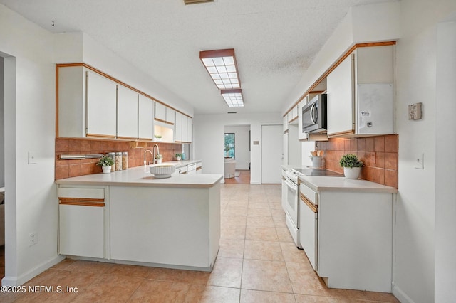 1918 Oak Cir, Atlantic Beach, FL 32233 - kitchen with electric stove, stainless steel microwave, light countertops, and decorative backsplash