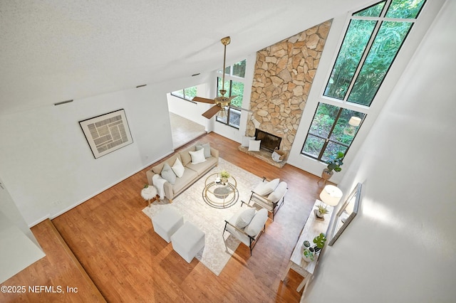 1918 Oak Cir, Atlantic Beach, FL 32233 - living room with wood finished floors, high vaulted ceiling, a fireplace, ceiling fan, and a textured ceiling