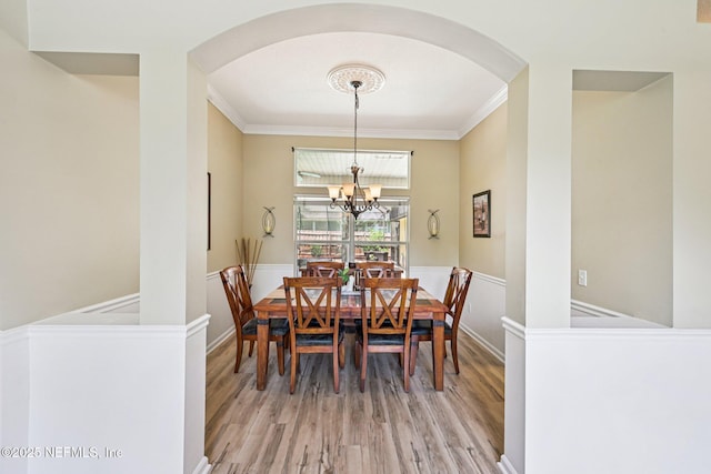 1400 Gibralter Ln, Fleming Island, FL 32003 - dining area featuring arched walkways, light wood-style flooring, a chandelier, and ornamental molding