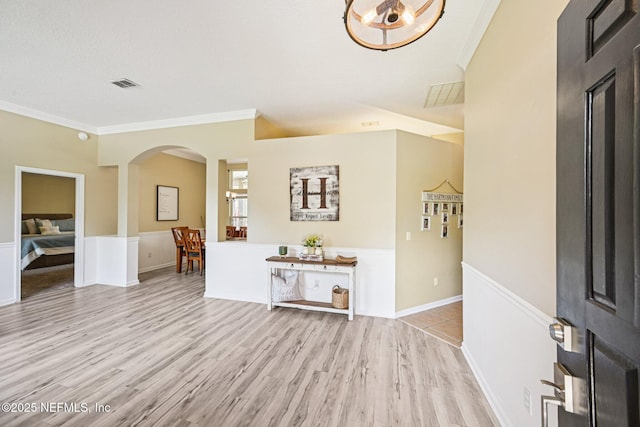 1400 Gibralter Ln, Fleming Island, FL 32003 - entryway with arched walkways, ornamental molding, wood finished floors, and a wainscoted wall