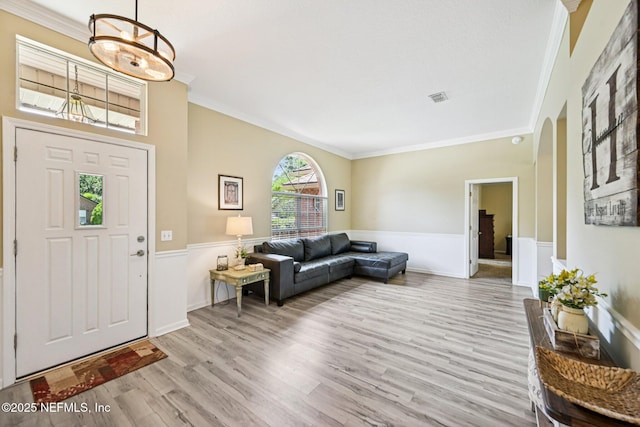 1400 Gibralter Ln, Fleming Island, FL 32003 - entrance foyer featuring ornamental molding, a wainscoted wall, wood finished floors, and arched walkways
