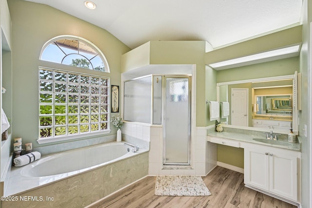 1400 Gibralter Ln, Fleming Island, FL 32003 - bathroom with a stall shower, a garden tub, vanity, wood finished floors, and lofted ceiling