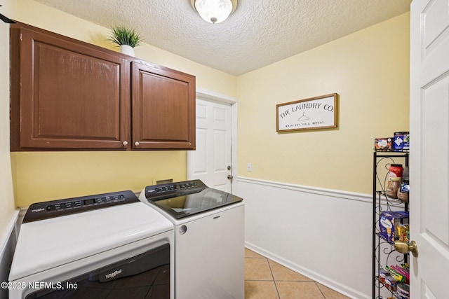 1400 Gibralter Ln, Fleming Island, FL 32003 - washroom featuring cabinet space, washing machine and dryer, light tile patterned floors, and a textured ceiling