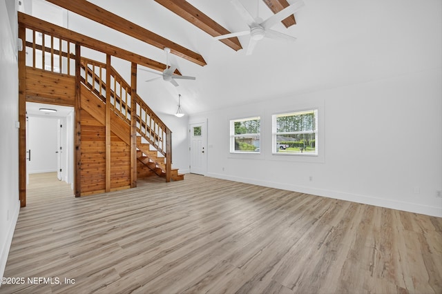 15 Katrina Pl, Palm Coast, FL 32164 - unfurnished living room featuring a ceiling fan, stairway, beam ceiling, high vaulted ceiling, and light wood-style flooring