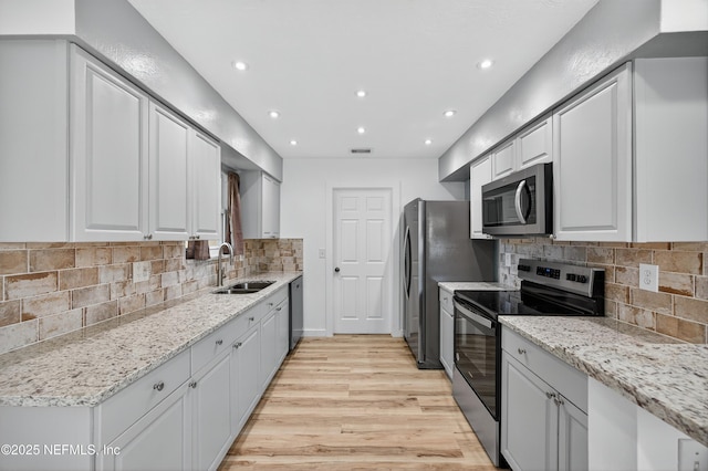 15 Katrina Pl, Palm Coast, FL 32164 - kitchen featuring stainless steel appliances, light wood-type flooring, recessed lighting, light stone counters, and tasteful backsplash