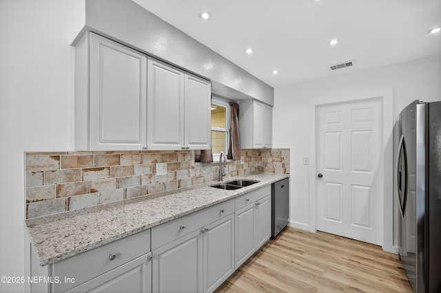 15 Katrina Pl, Palm Coast, FL 32164 - kitchen featuring stainless steel appliances, light wood-type flooring, tasteful backsplash, light stone counters, and recessed lighting