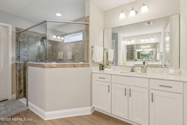 83316 Chapel Ct, Fernandina Beach, FL 32034 - bathroom with tiled shower, vanity, and wood finished floors