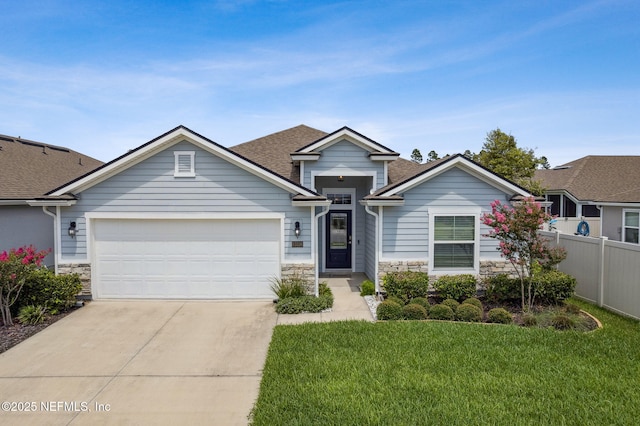 83316 Chapel Ct, Fernandina Beach, FL 32034 - view of front facade with stone siding, a garage, driveway, and roof with shingles
