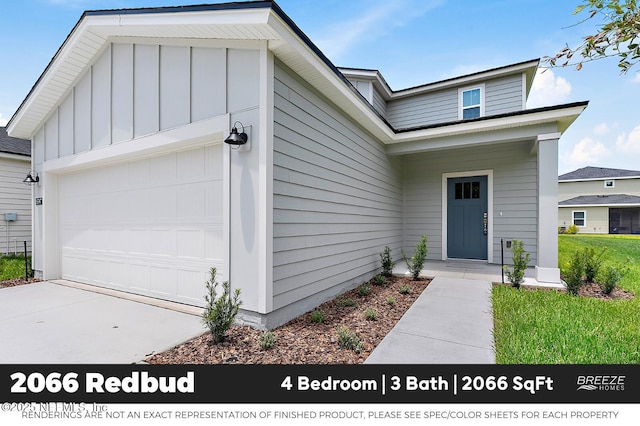 9018 Whinny Way Lot 276, Jacksonville, FL 32219 - doorway to property featuring an attached garage, concrete driveway, and board and batten siding