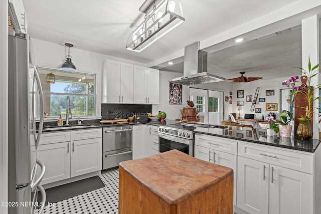 6241 Riviera Manor Dr, Jacksonville, FL 32216 - kitchen with island range hood, stainless steel appliances, white cabinetry, recessed lighting, and tasteful backsplash