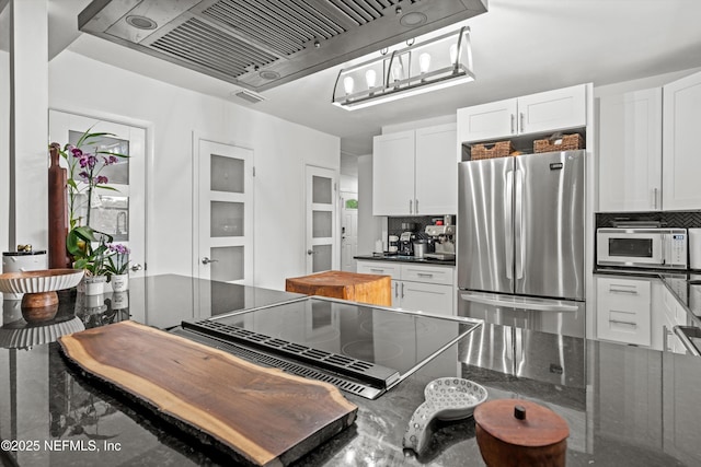 6241 Riviera Manor Dr, Jacksonville, FL 32216 - kitchen with freestanding refrigerator, white microwave, ventilation hood, and backsplash