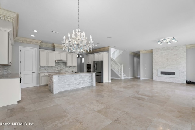 2936 Brettungar Dr, Jacksonville, FL 32246 - kitchen featuring appliances with stainless steel finishes, tasteful backsplash, open floor plan, light countertops, and crown molding