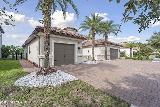 2936 Brettungar Dr, Jacksonville, FL 32246 - mediterranean / spanish-style home with an attached garage, decorative driveway, a tile roof, and stucco siding