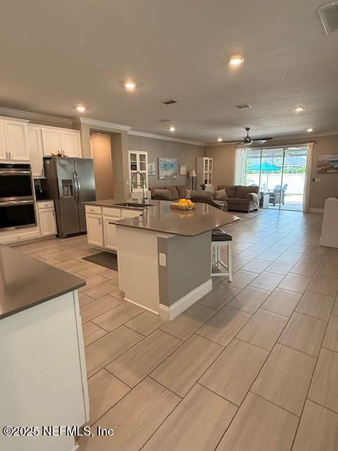 296 Latrobe Ave, Saint Augustine, FL 32095 - kitchen featuring fridge with ice dispenser, open floor plan, a large island with sink, stainless steel double oven, and ornamental molding