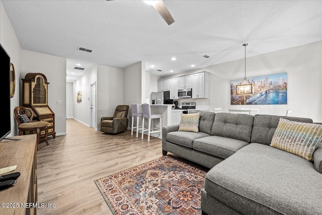 1515 Landau Rd, Jacksonville, FL 32225 - living room featuring light wood finished floors, a textured ceiling, recessed lighting, and a ceiling fan