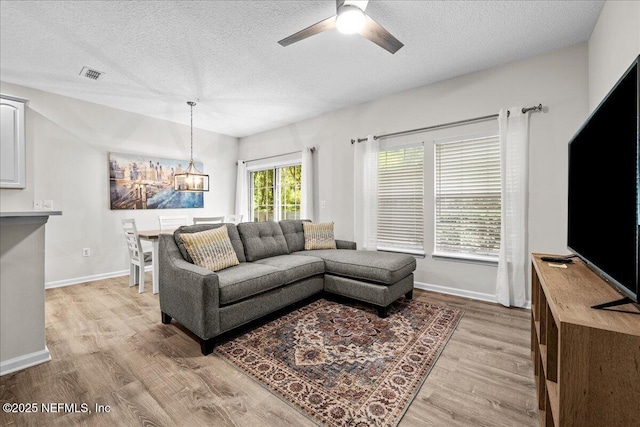 1515 Landau Rd, Jacksonville, FL 32225 - living area with a textured ceiling, light wood finished floors, ceiling fan, and a chandelier