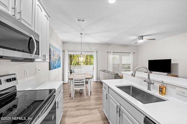 1515 Landau Rd, Jacksonville, FL 32225 - kitchen with stainless steel appliances, open floor plan, a textured ceiling, light countertops, and a ceiling fan