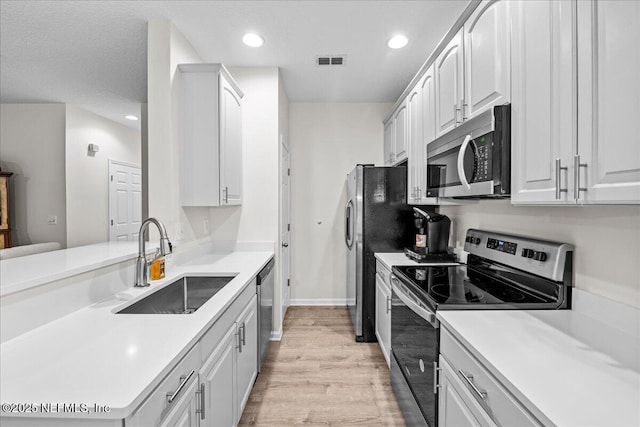 1515 Landau Rd, Jacksonville, FL 32225 - kitchen with stainless steel appliances, light wood-style floors, light countertops, recessed lighting, and white cabinetry