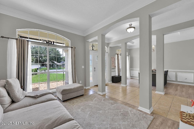 1728 Dartmoor Ln, Ponte Vedra, FL 32081 - tiled living room featuring crown molding, arched walkways, and a textured ceiling