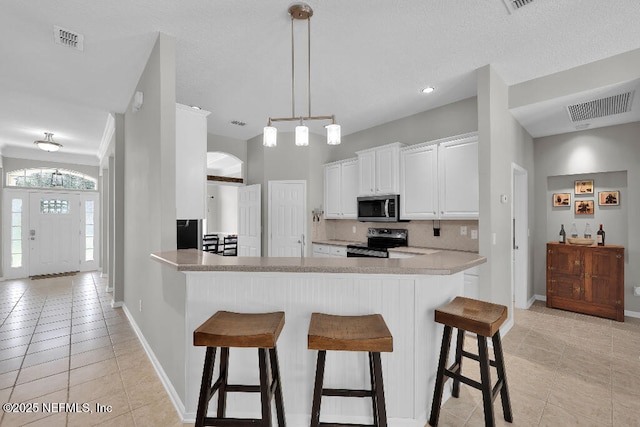 1728 Dartmoor Ln, Ponte Vedra, FL 32081 - kitchen with stainless steel appliances, light tile patterned floors, tasteful backsplash, a peninsula, and light countertops