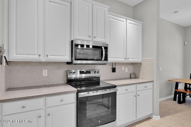 1728 Dartmoor Ln, Ponte Vedra, FL 32081 - kitchen with stainless steel appliances, white cabinetry, decorative backsplash, and light tile patterned floors