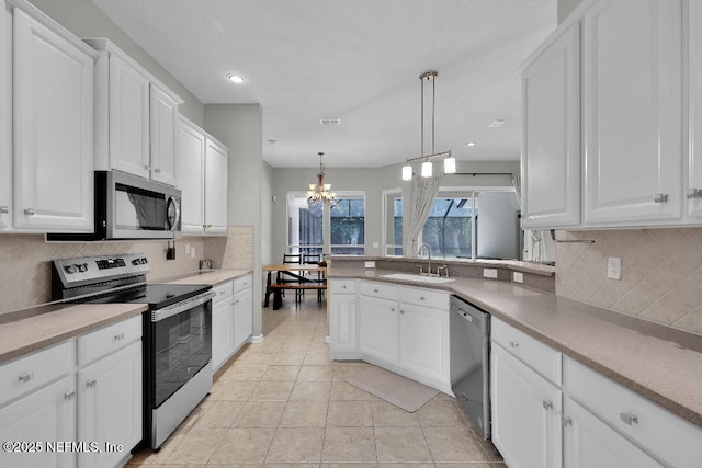 1728 Dartmoor Ln, Ponte Vedra, FL 32081 - kitchen with appliances with stainless steel finishes, white cabinets, a chandelier, backsplash, and recessed lighting