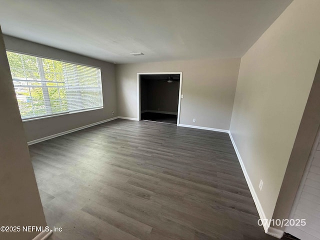 3421 Tarpon Dr, Jacksonville, FL 32277 - unfurnished room with baseboards and dark wood-type flooring