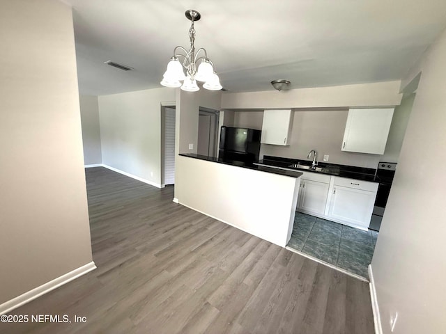 3421 Tarpon Dr, Jacksonville, FL 32277 - kitchen with freestanding refrigerator, stainless steel range with electric cooktop, white cabinets, a chandelier, and dark countertops