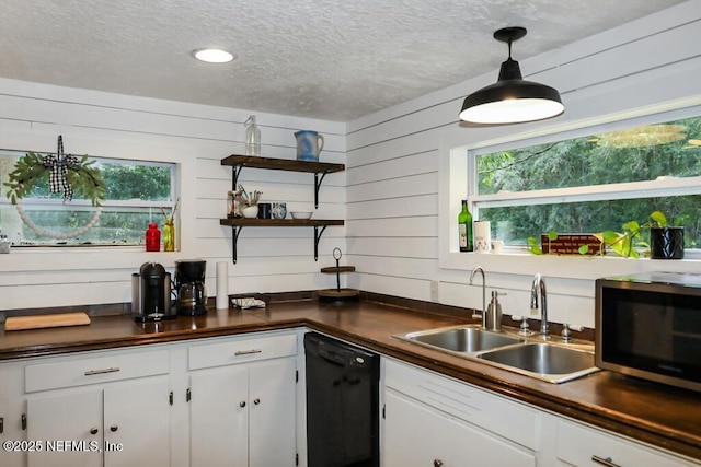 8360 Mudlake Rd, Macclenny, FL 32063 - kitchen featuring black dishwasher, stainless steel microwave, a textured ceiling, dark countertops, and white cabinetry