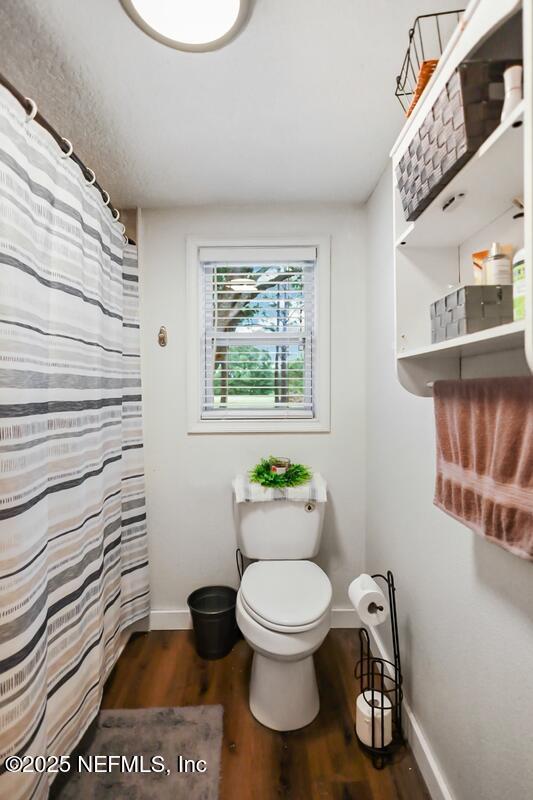 8360 Mudlake Rd, Macclenny, FL 32063 - full bath featuring wood finished floors and a shower with shower curtain