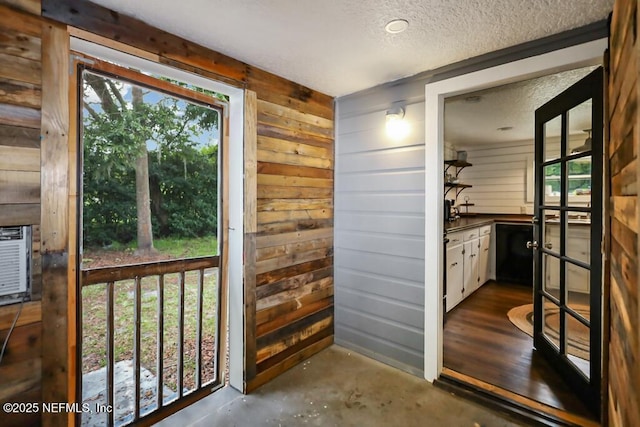 8360 Mudlake Rd, Macclenny, FL 32063 - doorway with a textured ceiling, wooden walls, and concrete floors