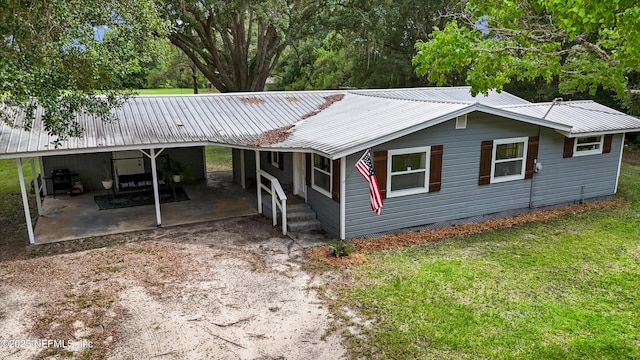 8360 Mudlake Rd, Macclenny, FL 32063 - view of front facade with a metal roof, a front lawn, a patio area, a carport, and driveway