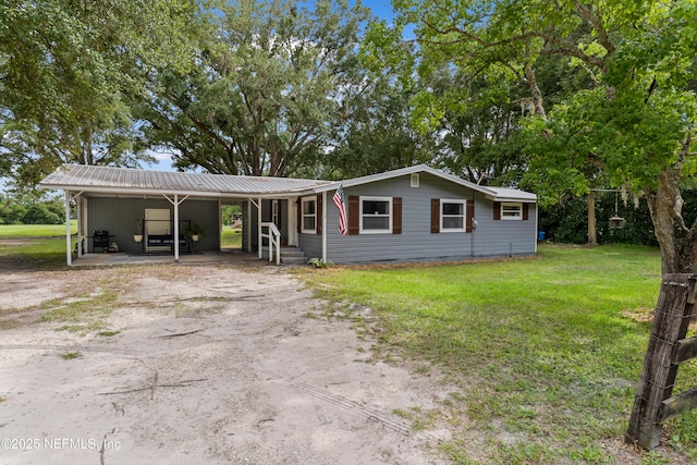 8360 Mudlake Rd, Macclenny, FL 32063 - view of front of home with driveway, a metal roof, an attached carport, and a front lawn