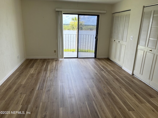 32 Ocean Palm Dr S Unit 320, Flagler Beach, FL 32136 - unfurnished bedroom with access to outside, wood finished floors, a water view, and two closets