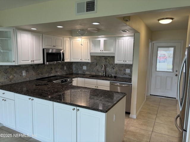 32 Ocean Palm Dr S Unit 320, Flagler Beach, FL 32136 - kitchen with stainless steel appliances, white cabinetry, light tile patterned floors, a peninsula, and tasteful backsplash