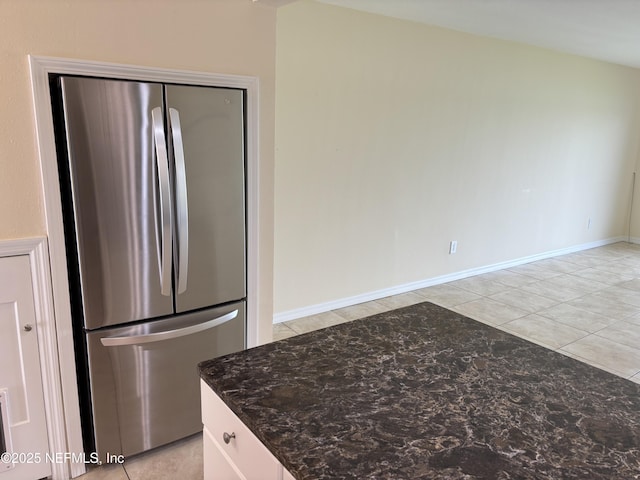 32 Ocean Palm Dr S Unit 320, Flagler Beach, FL 32136 - kitchen featuring freestanding refrigerator, dark stone counters, and light tile patterned flooring