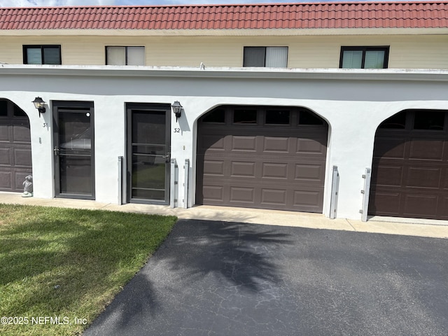 32 Ocean Palm Dr S Unit 320, Flagler Beach, FL 32136 - view of front of house with a tiled roof, driveway, stucco siding, and a garage