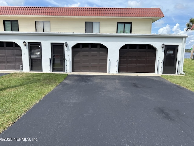 32 Ocean Palm Dr S Unit 320, Flagler Beach, FL 32136 - view of front of home featuring driveway, a tile roof, and a front yard