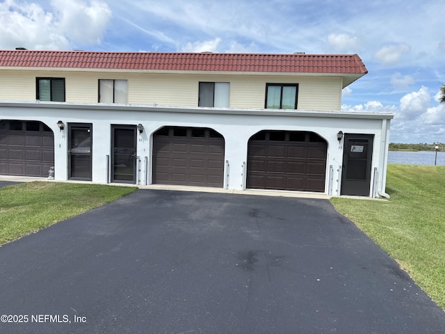 32 Ocean Palm Dr S Unit 320, Flagler Beach, FL 32136 - view of front of property with a tiled roof, driveway, and a front yard