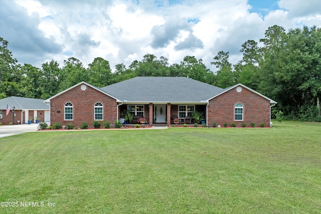 5566 Don Manuel Rd, Elkton, FL 32033 - ranch-style house with brick siding, a front lawn, covered porch, and view of scattered trees
