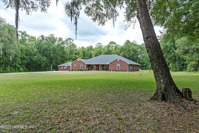5566 Don Manuel Rd, Elkton, FL 32033 - ranch-style home featuring a front yard, a chimney, and brick siding