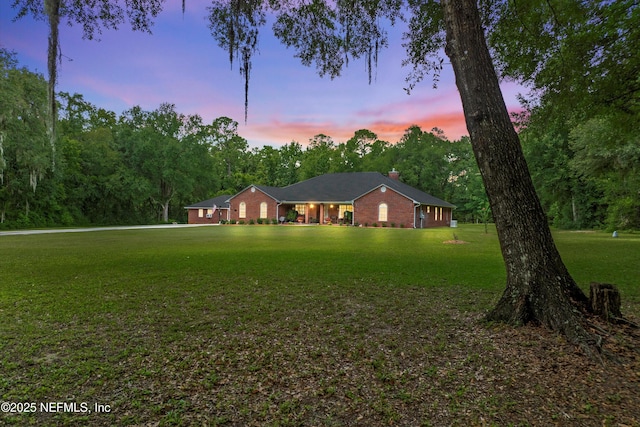 5566 Don Manuel Rd, Elkton, FL 32033 - ranch-style house featuring a front lawn, a chimney, and brick siding