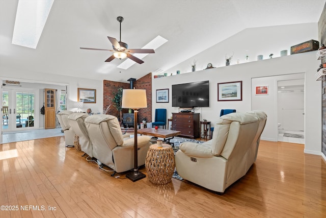 5566 Don Manuel Rd, Elkton, FL 32033 - living room featuring a skylight, a wood stove, light wood finished floors, ceiling fan, and high vaulted ceiling