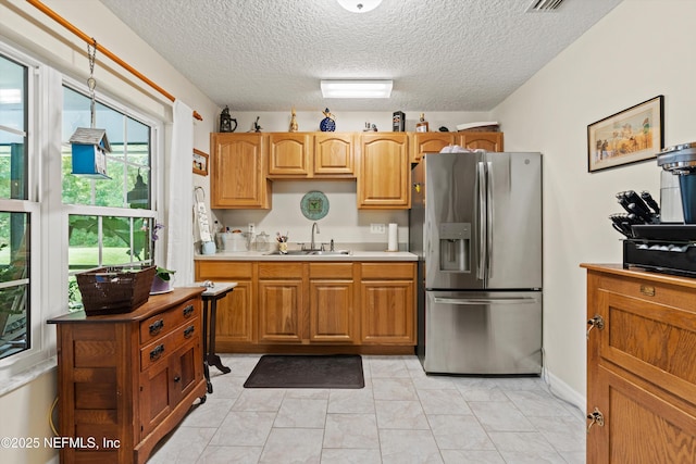 5566 Don Manuel Rd, Elkton, FL 32033 - kitchen with stainless steel fridge, a textured ceiling, and light countertops