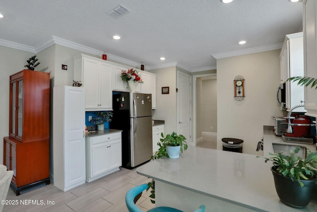 363 Latrobe Ave, Saint Augustine, FL 32095 - kitchen with stainless steel appliances, white cabinetry, recessed lighting, ornamental molding, and wood finish floors
